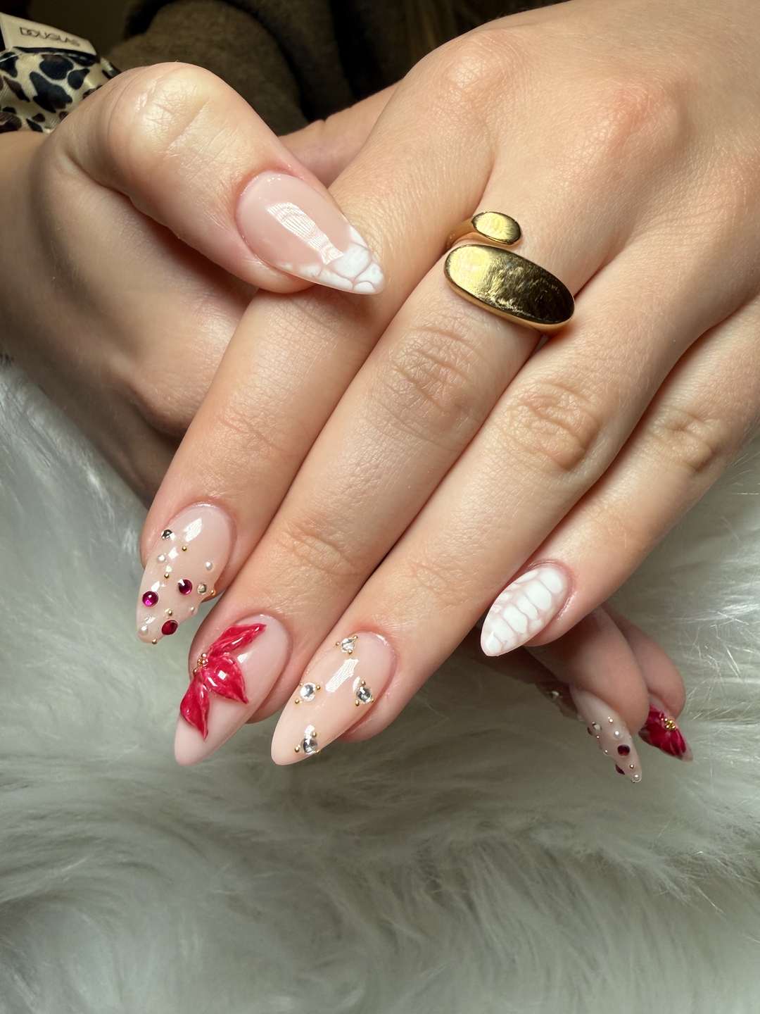 Nageldesign mit weißen Texturen, roten Blüten und Steinen